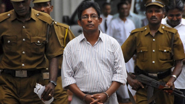 Sri Lankan prison guards escort ethnic Tamil journalist J.S. Tissainayagam out of the High Court premises in Colombo, Sri Lanka, Monday, Aug. 31, 2009.(AP)