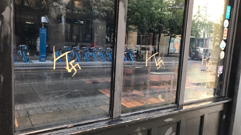Racist graffiti is seen on the windows of the Calabash Bistro in downtown Vancouver in this Facebook image. (Roger Collins) 