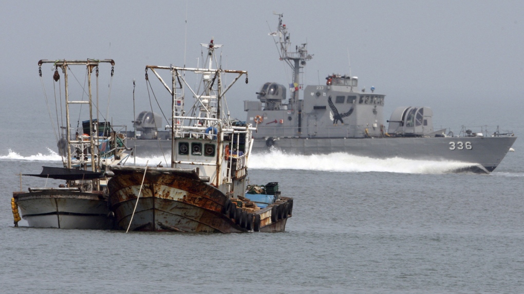 South Korean navy vessel passes fishing boats