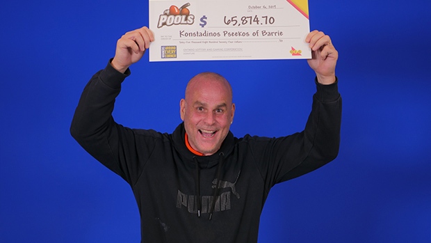 A Barrie bar owner holds up the big cheque from OLG after winning with POOLS. (Fri., Oct. 18, 2019 - Supplied)