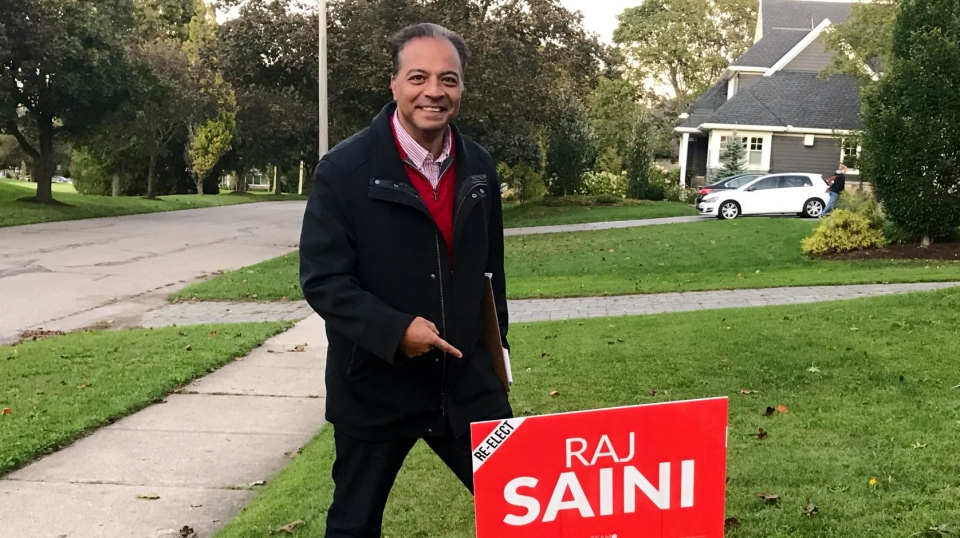 Raj Saini poses next to an election sign in this file photo. (@RajSaini4KitCen / Twitter)
