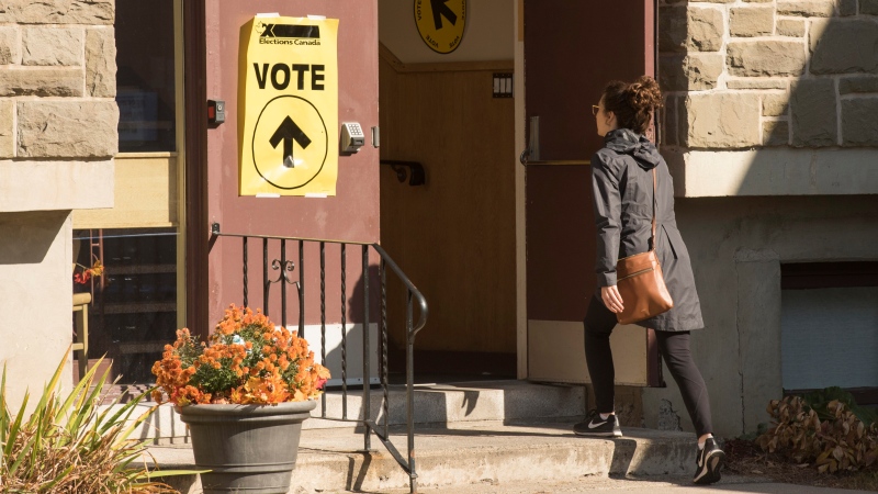 A woman walks into Christ Church (Parish) Church, where they can vote in the federal election in Fredericton, Monday, Oct. 21, 2019. (THE CANADIAN PRESS/Stephen MacGillivray)