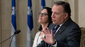 Quebec Premier Francois Legault reacts to the election of a Liberal minority government at the National Assembly in Quebec City, Tuesday, Oct. 22, 2019. Quebec Justice Minister and Minister Responsible for Canadian Relations and the Canadian Francophonie Sonia Lebel, left, looks on. THE CANADIAN PRESS/Jacques Boissinot
