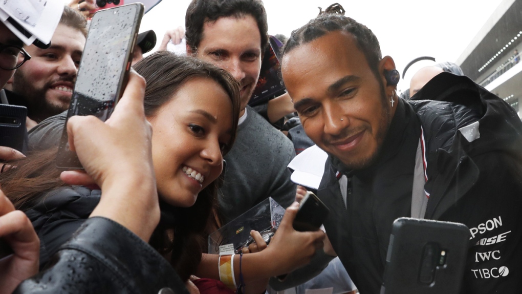 Lewis Hamilton poses for photos with his fans
