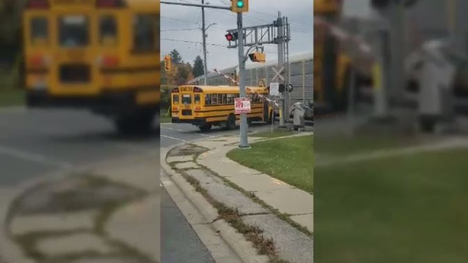 Video shows school bus caught under railroad cross
