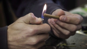 A man lights a marijuana cigarette at on April 25, 2017. (THE CANADIAN PRESS/Joe Mahoney)
