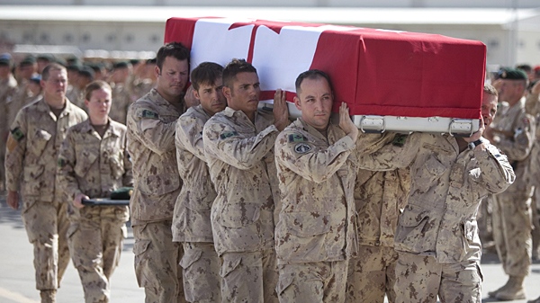 Canadian soldiers carry the flag-draped coffin of Maj. Yannick Pepin at a ramp ceremony at Kandahar Airfield in Afghanistan on Monday, Sept. 7, 2009. (Bill Graveland / THE CANADIAN PRESS)