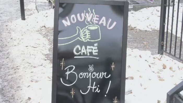 A cafe sign with the greeting Bonjour, hi.