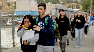 This Nov. 14, 2019 file photo shows students being escorted out of Saugus High School after a shooting on the campus in Santa Clarita, Calif. Authorities say the teenager who shot five classmates, killing two, at a Southern California high school used an unregistered "ghost gun." Los Angeles County Sheriff Alex Villanueva Villanueva told media outlets Thursday, Nov. 21, 2019 that Nathaniel Tennosuke Berhow's semi-automatic handgun had been assembled and did not have a serial number. Authorities are still working to determine how Berhow got the handgun. Berhow died from a self-inflicted gunshot wound after the shooting. (AP Photo/Marcio Jose Sanchez, File)