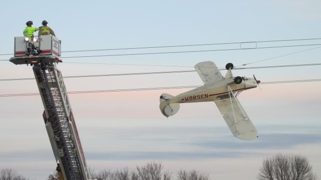 According to a statement from police, a single engine prop Piper Cub was traveling south when it hit a cluster of power lines and became tangled with a guideline, upside down. (Scott County Sheriff's Office)