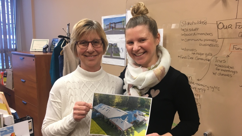 Executive director of Community Living London Michelle Palmer and staff member Anna Tavener hold a picture of the home purchased being renovated in London, Ont., on Tuesday, Dec. 3, 2019. (Celine Zadorsky / CTV London)