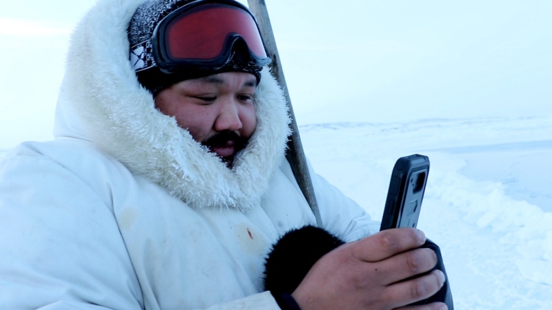 Puasi Ippak tests out the Siku mobile app in a handout photo. A social media app geared towards the outdoor lives of Inuit launched Wednesday with features that tie traditional knowledge to smart phone technology. (THE CANADIAN PRESS/HO-Arctic Eider Society)