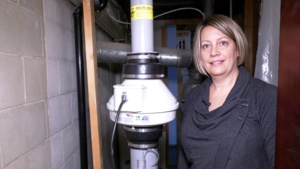 Marci Tyc and the radon mitigation system she had installed in November. (Source: Michelle Gerwing/ CTV News Winnipeg)