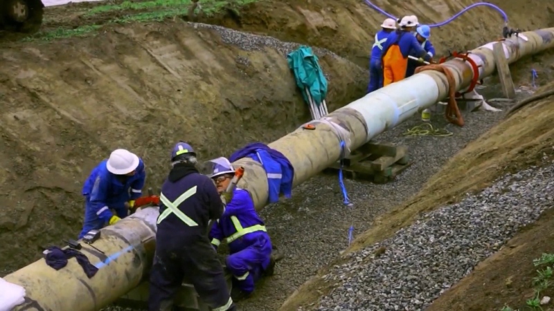 File photo of workers laying of pipeline in a trench, 