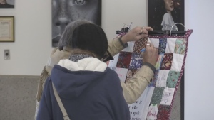 Names are handwritten on a quilt on display in Barrie to honour those who lost their lives while living on the streets. Fri., Dec. 20, 2019. (Craig Momney, CTV News)