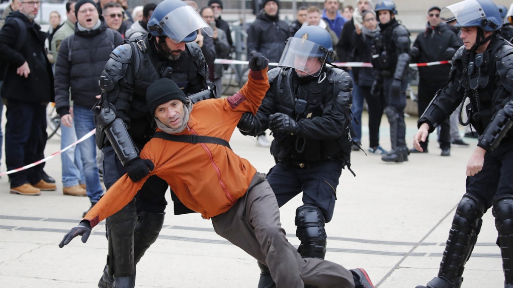 Riot police detain striking train worker in Paris