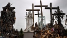 In this photo taken on Wednesday, July 17, 2019, statues of the Virgin Mary and crosses are photographed at the Hill of Crosses a Lithuanian national pilgrimage site near the city of Siauliai, Lithuania. Lithuania officials have condemned the actions of a Chinese tourist who vandalized the Baltic country's top religious heritage site. A video, originally posted on Instagram in November, 2019 but that came to the Lithuanian public’s attention over the weekend, shows a woman removing a wooden cross that expressed support for the Hong Kong pro-democracy movement from the Hill of Crosses, a large mount adorned with tens of thousands of crosses left by pilgrims and visitors. (AP Photo/Mindaugas Kulbis)