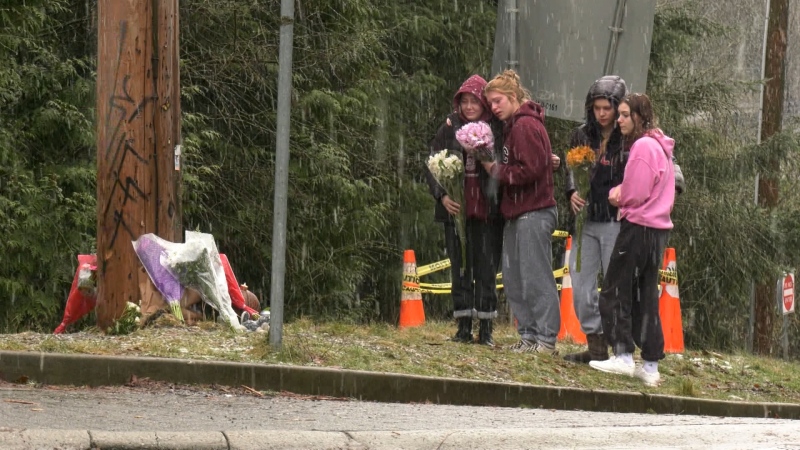 Kerri Houston and three friends brought bouquets of flowers Sunday to the growing memorial at the intersection where Elijah Drasyl's BMW struck a telephone pole. (CTV)