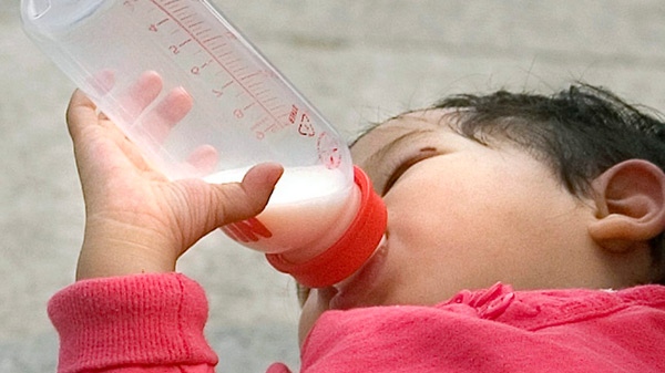 A one-year-old Chinese girl drinks from a bottle in her mother's arms while taking a rest in Tiananmen Square, Beijing on Thursday, Oct. 2, 2008. (AP / Alexander F. Yuan)