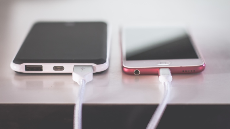 Two kinds of smartphone charging cables are plugged in. (Pexels/Steve Johnson)
