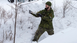 A soldier from the 4th Artillery Regiment based at CFB Gagetown clears snow at a residence in St. John's on Monday, January 20, 2020. THE CANADIAN PRESS/Andrew Vaughan