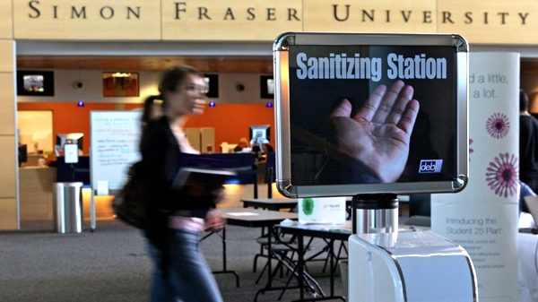 A student walks past a hand sanitizer dispenser at Simon Fraser University in Surrey, B.C., on Thursday, September 10, 2009. The stations have been placed in the school to combat the spread of swine flu. (Darryl Dyck / THE CANADIAN PRESS)