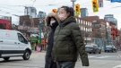 Pedestrians wear protective masks as they walk in Toronto on Monday, January 27, 2020. Canada's first presumptive case of the novel coronavirus has been officially confirmed, Ontario health officials said Monday as they announced the patient's wife has also contracted the illness. THE CANADIAN PRESS/Frank Gunn