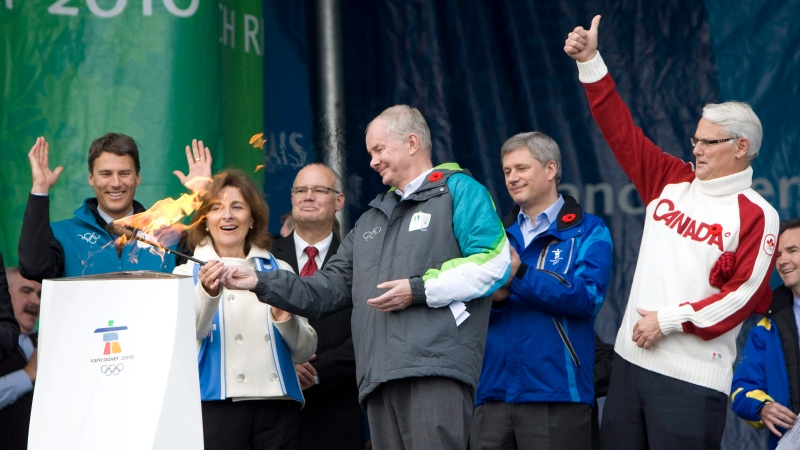 VANOC Chief Executive Officer John Furlong, centre, lights the community cauldron as Vancouver Mayor Gregor Robertson, left to right, Darlene Poole, Prime Minister Stephen Harper and British Columbia Premier Gordon Campbell look on in Victoria, B.C., Friday, Oct. 30, 2009. (THE CANADIAN PRESS/Jonathan Hayward)