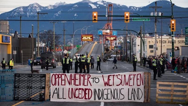 Police officers stand on the road after clearing the intersection of protesters that were blocking an entrance to the port during a demonstration in solidarity with Wet'suwet'en hereditary chiefs opposed to construction of a natural gas pipeline across their traditional territories, in Vancouver, on Monday February 10, 2020. THE CANADIAN PRESS/Darryl Dyck