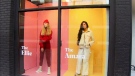 Women stand behind a Toronto storefront window as part of a campaign launched by Covenant House Toronto called "Shoppable Girls." (CTV News Toronto) 