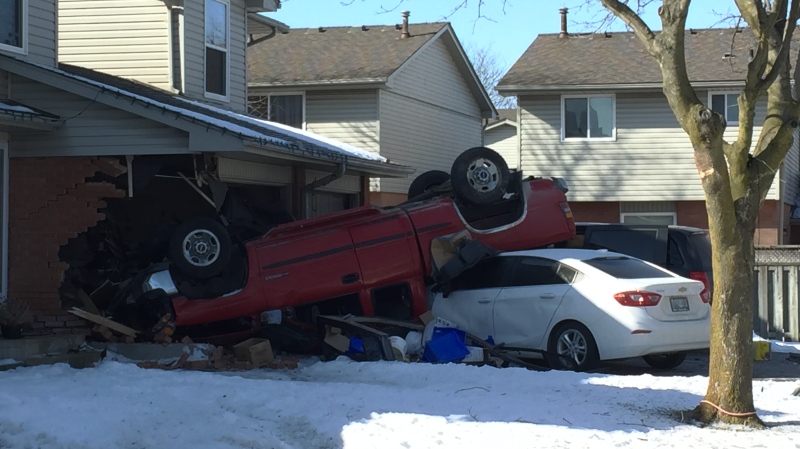 A red pick up truck flipped and crashed into a garage on Jalna Boulevard Friday. (Bryan Bicknell / CTV London)