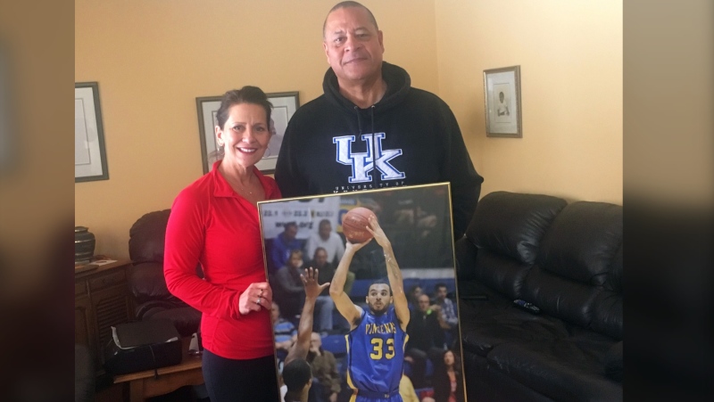 Randy Mulder, right, and his wife Claire proudly display a photo of their son Mychal, who made his NBA debut with the Golden State Warriors Thursday night. (Courtesy Randy Mulder)