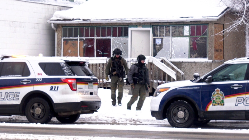 Saskatoon Police Service members wearing tactical gear exiting a 33rd Street West home on March 4, 2020.