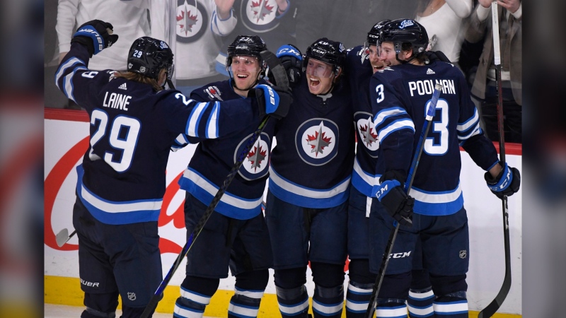 Winnipeg Jets' Cody Eakin, centre, celebrates his goal against the Arizona Coyotes with Patrik Laine, left to right, Nikolaj Ehlers (27), Nathan Beaulieu (88) and Tucker Poolman (3) during third period NHL action in Winnipeg on Monday, Mar. 9, 2020. THE (Source: The Canadian Press/Fred Greenslade)