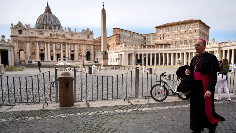 A prelate walks outside St. Peter's Square after the Vatican erected a new barricade at the edge of the square, in Rome, Tuesday, March 10, 2020. Italy entered its first day under a nationwide lockdown after a government decree extended restrictions on movement from the hard-hit north to the rest of the country to prevent the spreading of coronavirus. (AP Photo/Andrew Medichini)