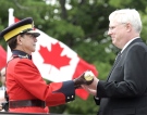 The new RCMP commissioner, William Elliott (right), is presented with the Tipstaff by outgoing commissioner, Bev Busson, at the RCMP change of command ceremony in Ottawa, August 10, 2007. (CP / Patrick Doyle)