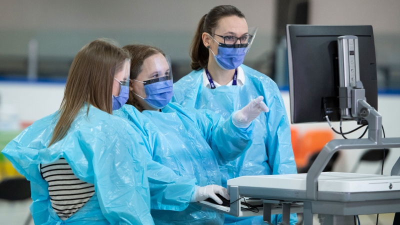 Medical staff work at a computer terminal as they prepare for the opening of the COVID-19 Assessment Centre at Brewer Park Arena in Ottawa, during a media tour on Friday, March 13, 2020. The assessment centre, operated by The Ottawa Hospital and CHEO, is an out-of-hospital clinic where people can be assessed and tested for COVID-19 if required. THE CANADIAN PRESS/Justin Tang