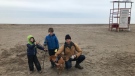 Fraser Teeple, right, along with his children, Sawyer and Wes, and dog Timber enjoy the early morning quiet on Port Stanley Beach, Tuesday, March 24, 2020. (Sean Irvine / CTV London)