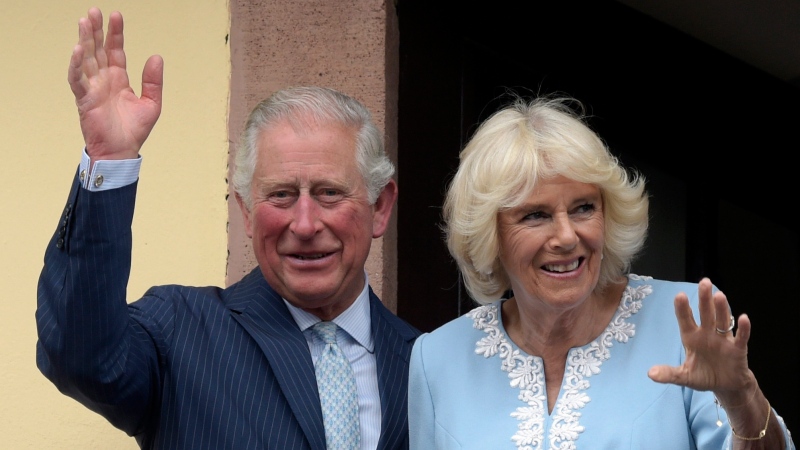 FILE - In this Wednesday, May 8, 2019 file photo, Britain's Prince Charles and Camilla, Duchess of Cornwall wave from the town hall balcony in Leipzig, Germany. (AP Photo/Jens Meyer, File)
