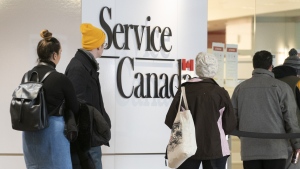 People line up at a Service Canada office in Montreal on Thursday, March 19, 2020. THE CANADIAN PRESS/Paul Chiasson