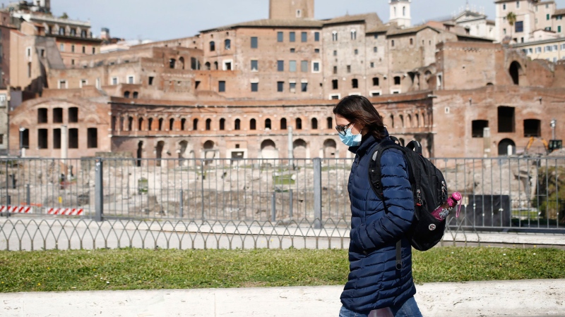 A woman walks past the Trajan's Forum in Rome, Tuesday, March 31, 2020. (Cecilia Fabiano/LaPresse via AP)