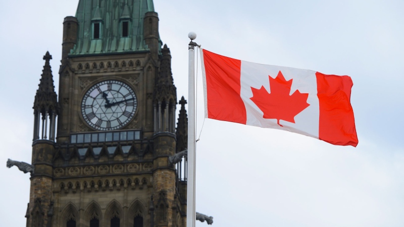 A Canadian flag flies by Parliament Hill in Ottawa on Friday, March 13, 2020. THE CANADIAN PRESS/Sean Kilpatrick