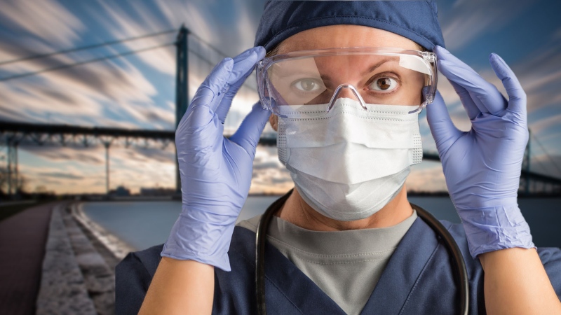File photo of a nurse with the Ambassador Bridge in the background. (Courtesy Getty Images)