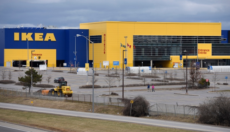 Two people walk in the deserted parking lot at IKEA in Ottawa, as it remains closed due to the COVID-19 pandemic, on Sunday, April 5, 2020. (Justin Tang/THE CANADIAN PRESS)