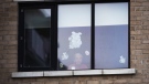 A woman looks through her window from inside an long-term care home. (The Canadian Press)