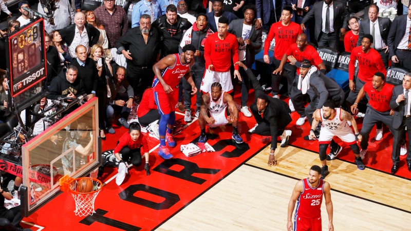 Kawhi Leonard (squatting, centre) of the Toronto Raptors watches his game-winning buzzer-beater shot go into the net, while playing against the Philadelphia 76ers in Game 7 of the Eastern Conference Semifinals of the 2019 NBA Playoffs, at the Scotiabank Arena, in Toronto, Canada, on 12 May 2019. THE CANADIAN PRESS/AP-Mark Blinch for NBAE