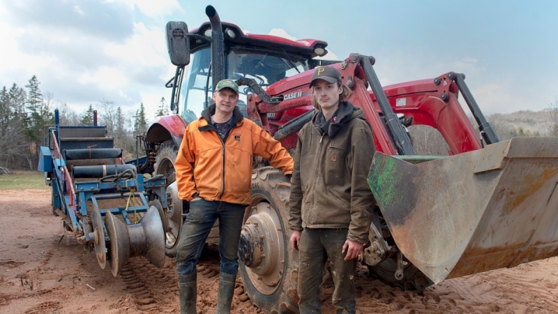 Greg Gerrits and his son James stand in front of a tractor on their family-owned Elmridge Farm in Centreville, N.S. on Friday, April 17, 2020. THE CANADIAN PRESS/Andrew Vaughan
