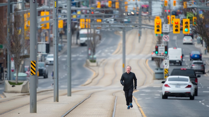 Lloyd Alter runs on the St. Clair Avenue streetcar tracks to avoid crowded sidewalks and park paths in Toronto on Friday, April 17, 2020. THE CANADIAN PRESS/Nathan Denette