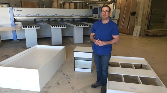Justin Hemming, of Hemmingwoods Commercial Millwork, stands amidst three low-cost beds manufactured for institutional used amidst COVID-19 in St. Thomas, Ont., Wednesday, April 22, 2020. (Sean Irvine / CTV London)