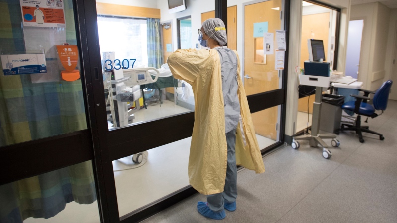 A nurse puts on her personal protective equipment prior to entering a patient's room in the COVID-19 intensive care unit at St. Paul's hospital in downtown Vancouver, Tuesday, April 21, 2020. THE CANADIAN PRESS/Jonathan Hayward